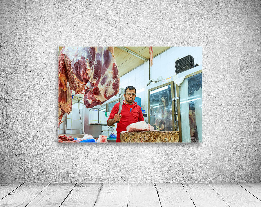 Butcher works with meat in a shop in Dubai UAE Wall Preview