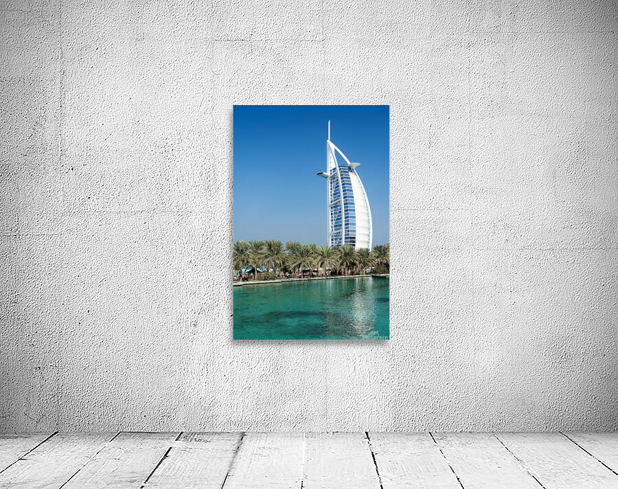 Burj Al Arab hotel stands tall by the water with palm trees Wall Preview