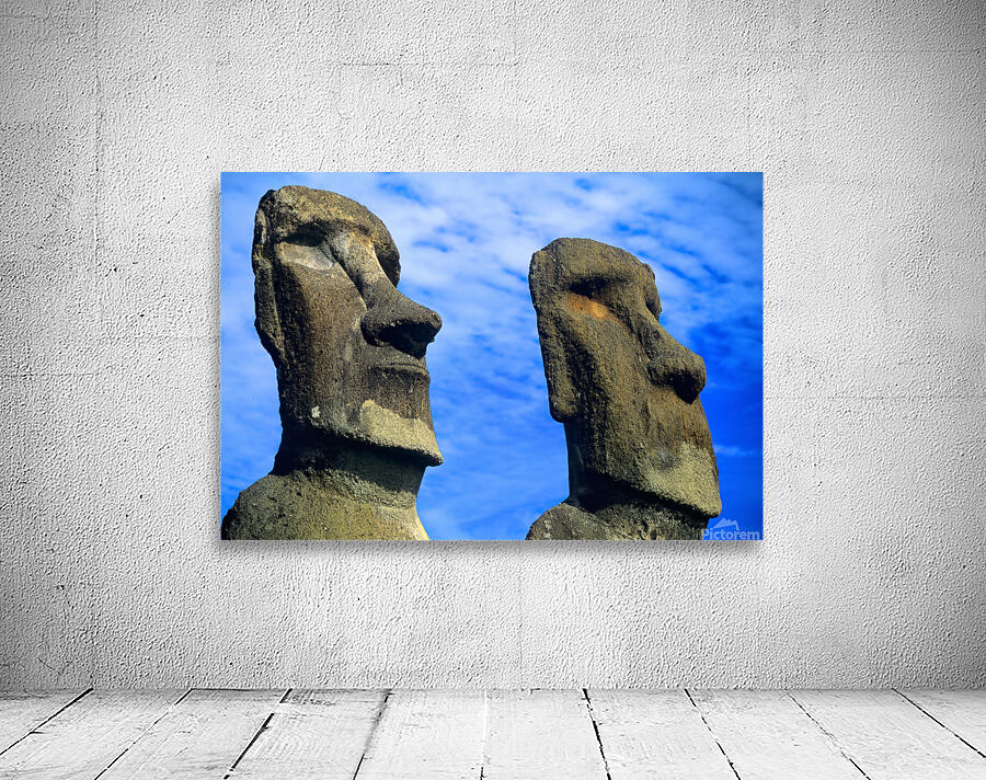 Two Moai statues against a blue sky. Wall Preview