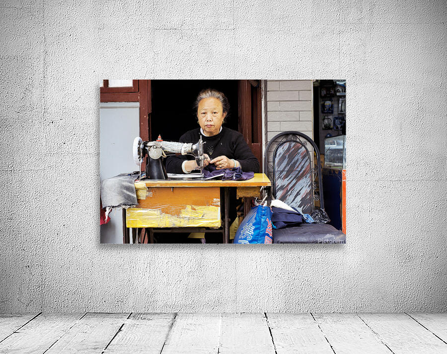 Elderly woman sews at machine in Shanghai China Wall Preview