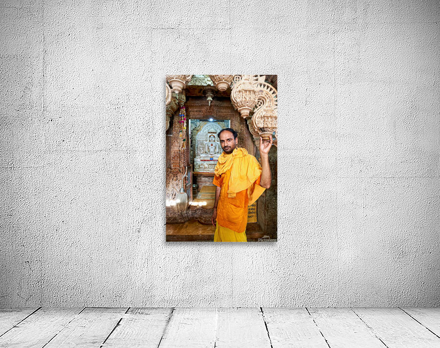 Hindu monk stands near statue in Jaisalmer Jain temple Wall Preview