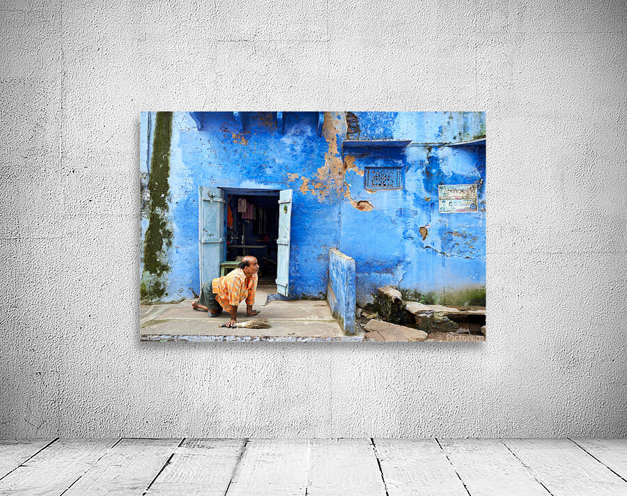 Man sweeps in front of home in Bundi Rajasthan during the day Wall Preview