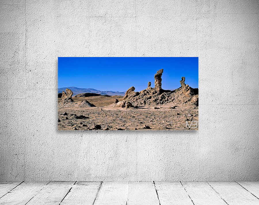 Arid desert with unusual rock pillars against a blue sky. Wall Preview