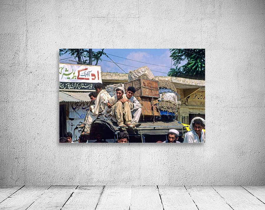 Men travel on top of a vehicle in Peshawar Pakistan Wall Preview