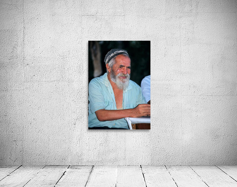 Elderly man smiles while sitting outdoors in Bukhara Uzbekistan Wall Preview