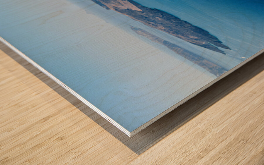 Cruise ship in deep blue sea volcanic islands rocky foreground Wood print