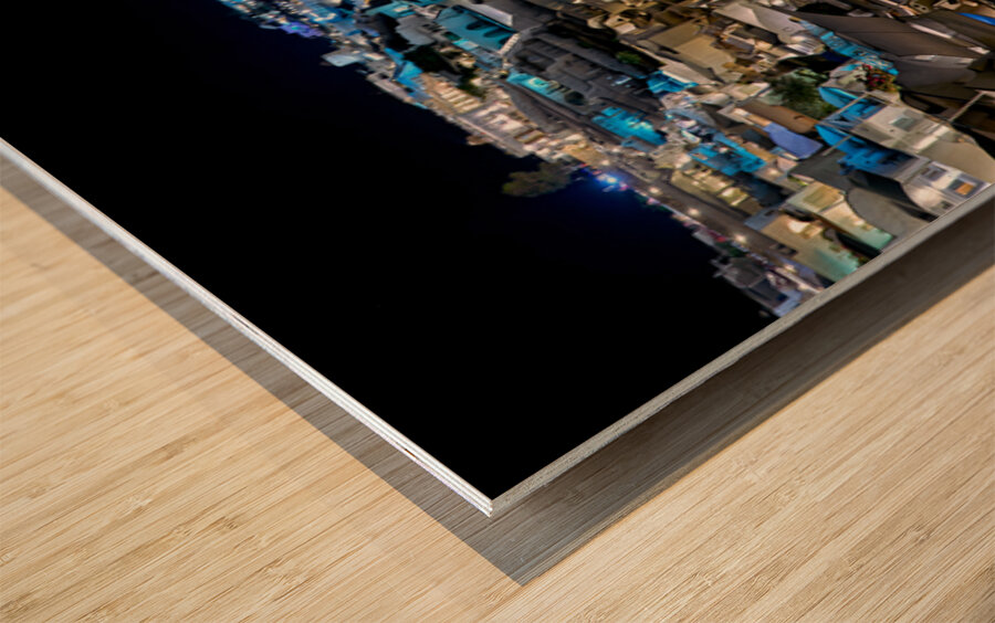 Illuminated cliffside town at night couple enjoying dinner. Wood print