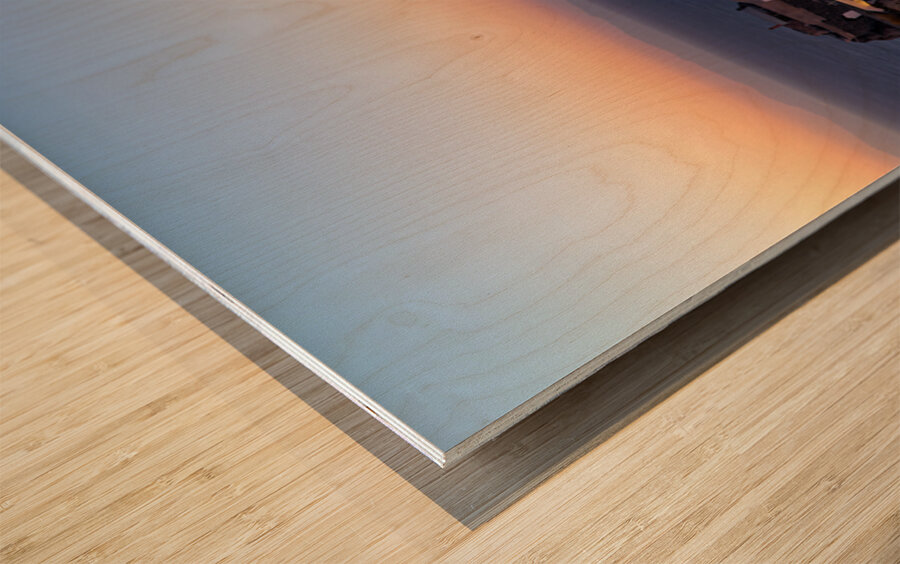 Santorinis Oia village glows at twilight by the sea. Wood print