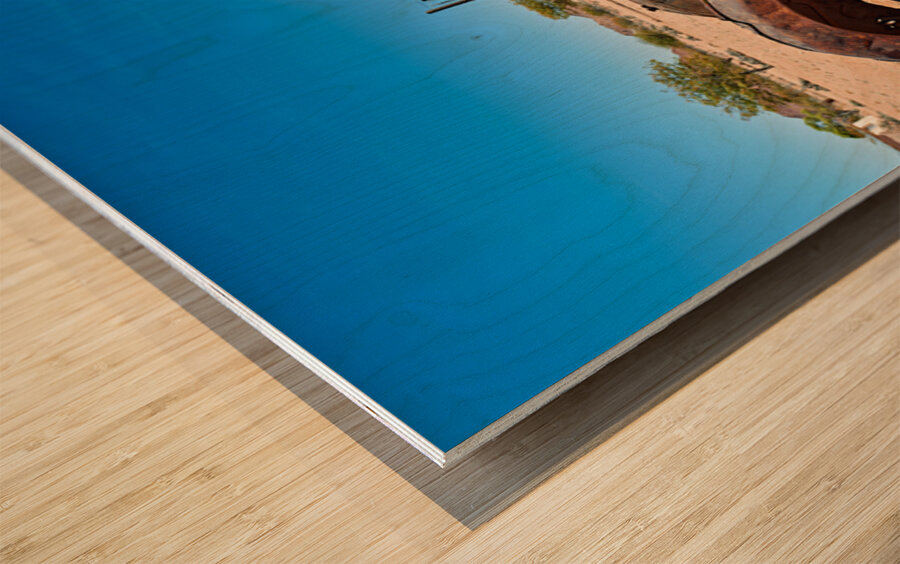 Classic car wreck rests in the Namib desert under a clear sky Wood print