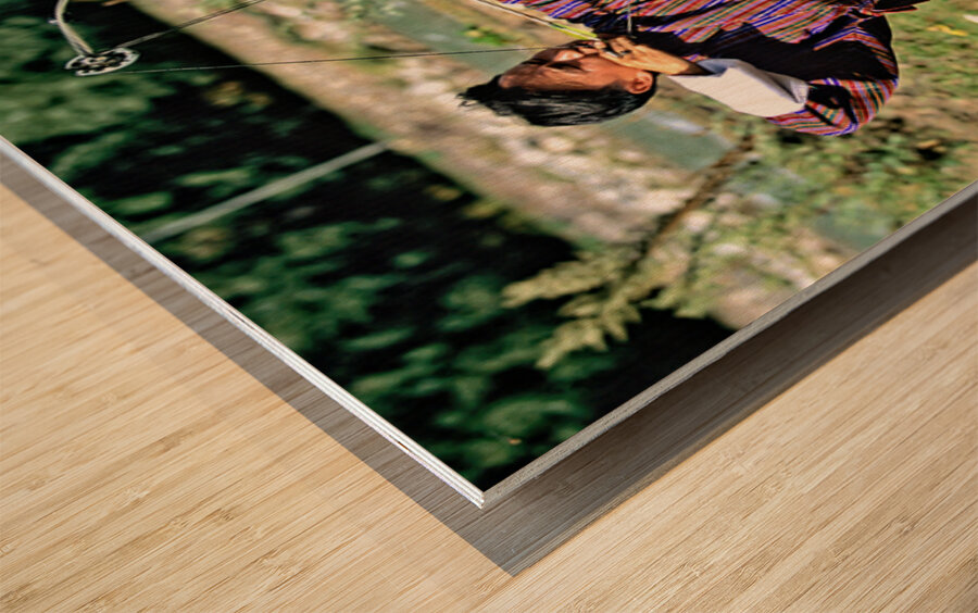 Bhutanese archer in traditional Gho aiming a compound bow. Wood print