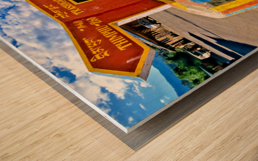 Colorful Bhutanese signpost directs to Thimphu and Trashigang. Wood print