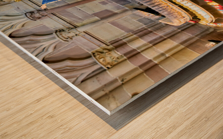 Visitors light votive candles near statue in Strasbourg Cathedra Wood print