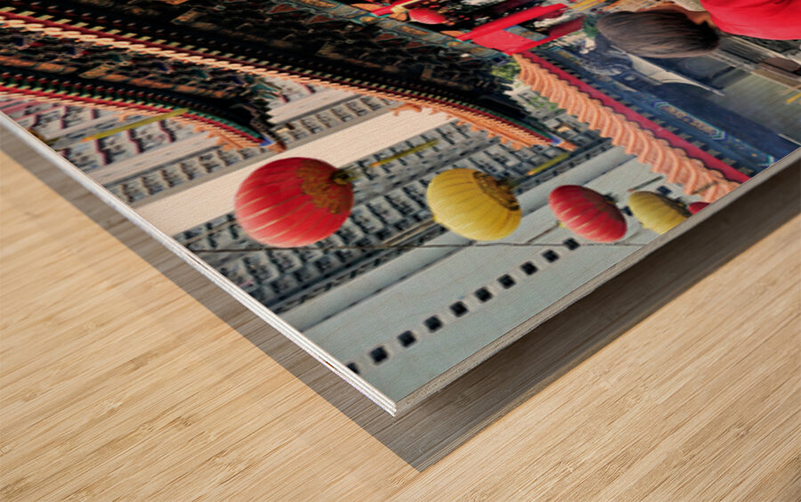 Woman prays with incense at colorful Chinese temple in Hong Kong Wood print