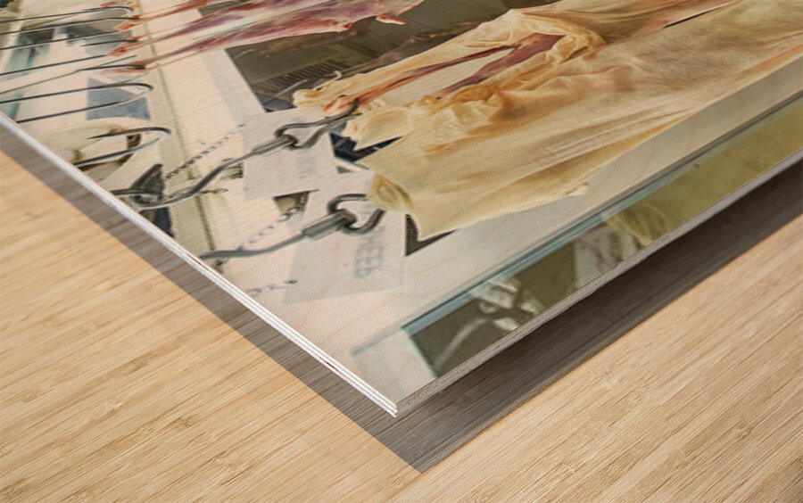 Butcher works in meat market in Dubai with hanging meat Wood print