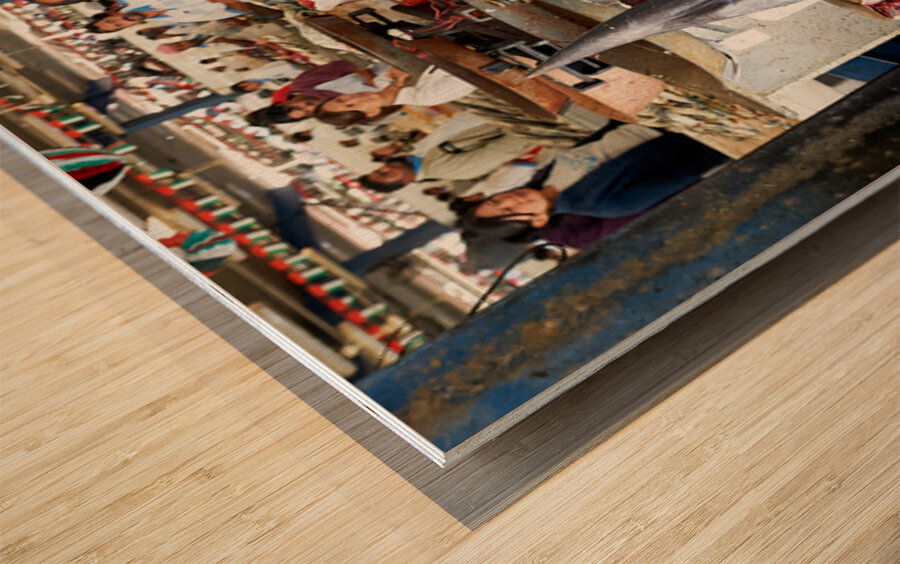 Man talks on phone at busy fish market in Dubai UAE Wood print