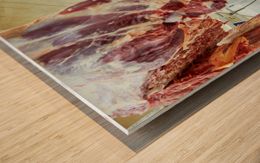 Butcher works with meat in a shop in Dubai UAE Wood print