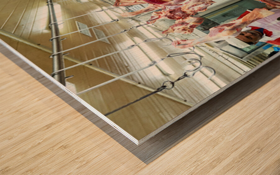 Butchers work at a busy meat market in Dubai UAE preparing fresh Wood print