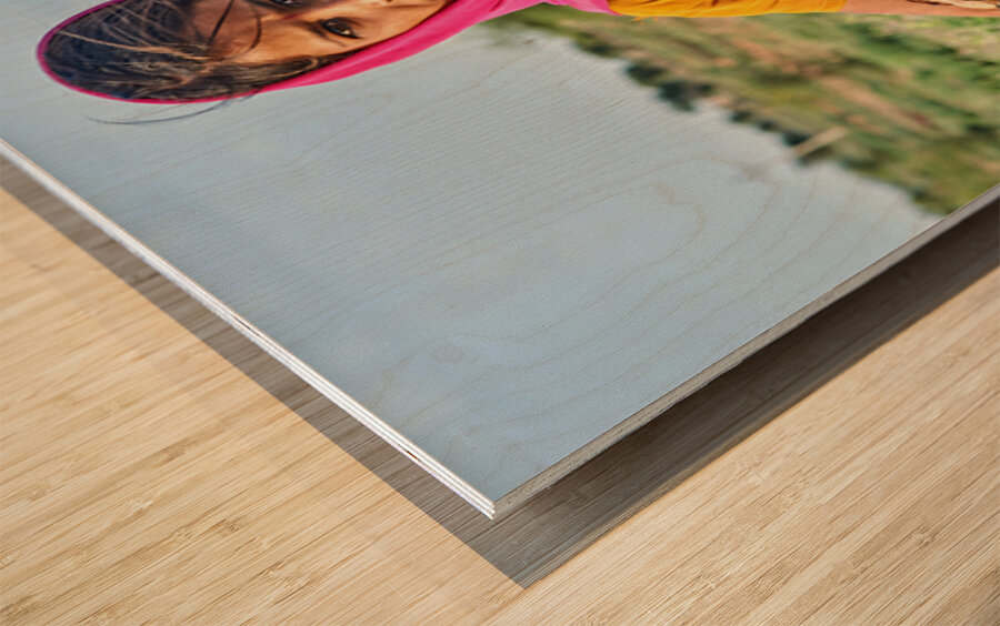 Girl holds goat in Khimsar Rajasthan India during sunny day Wood print