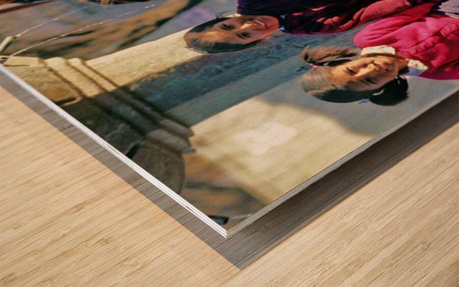 Smiling children and youth gather by a fountain. Wood print