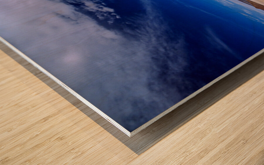 Vehicles traverse a vast arid salt flat landscape. Wood print