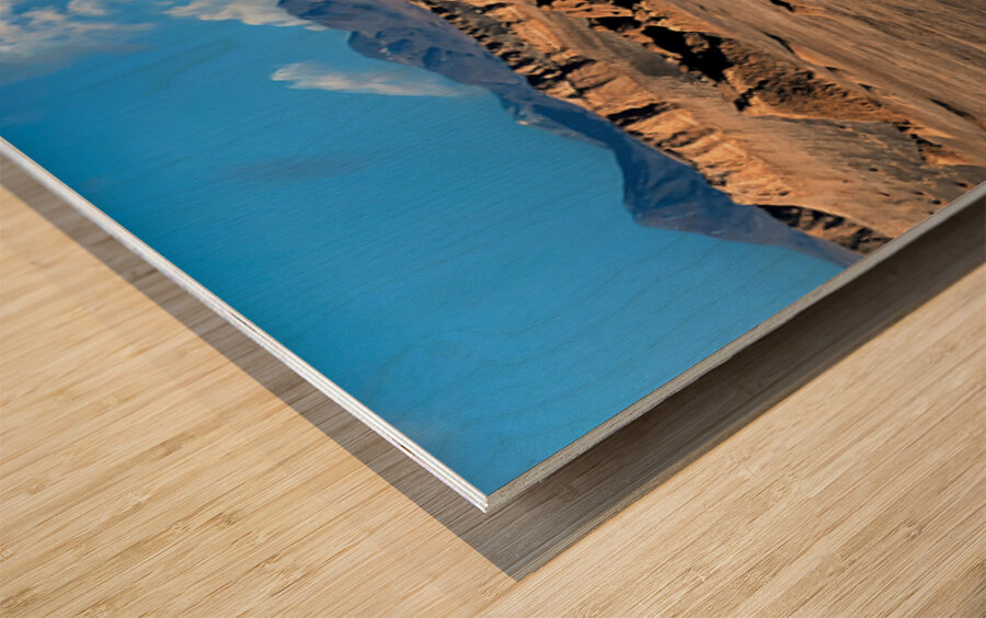 Rugged desert mountains under a clear blue sky with clouds. Wood print