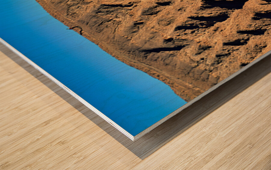 Hiker traverses a dramatic shadowed desert landscape. Wood print