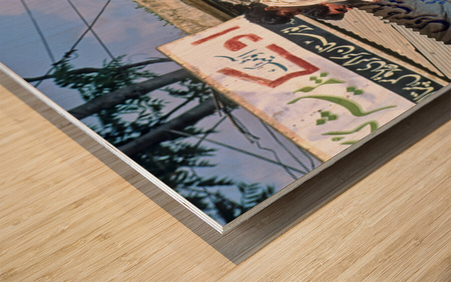 Men travel on top of a vehicle in Peshawar Pakistan Wood print