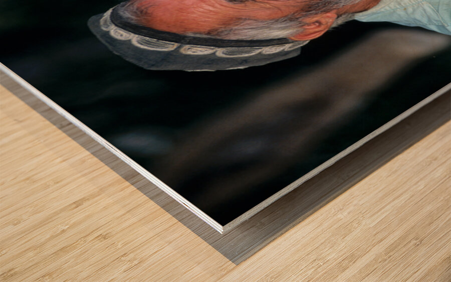 Elderly man smiles while sitting outdoors in Bukhara Uzbekistan Wood print