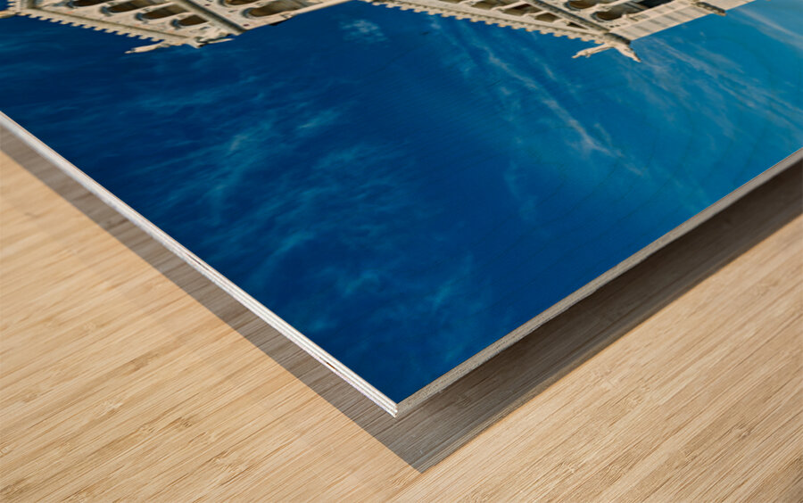 Visitors walk around Pisa Cathedral in Piazza dei Miracoli. The tall structure stands under a blue sky. People enjoy the lively atmosphere. Wood print