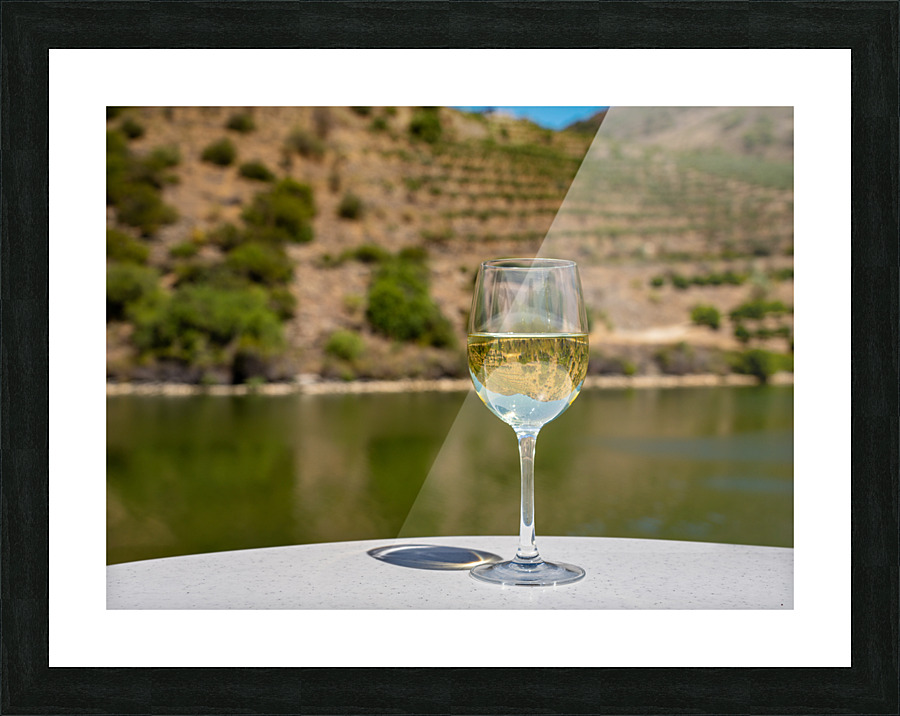 Glass of white wine by Douro river in Portugal Picture Frame print