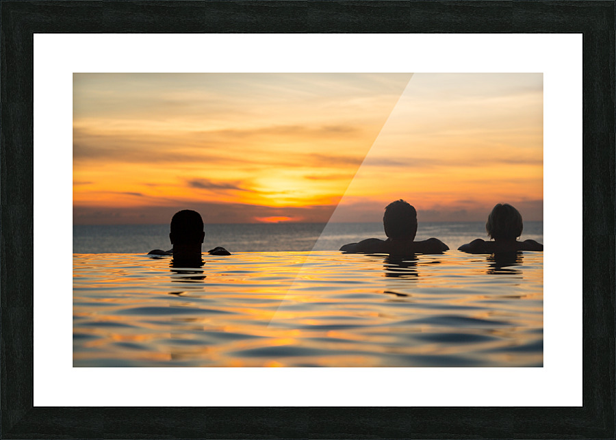 Silhouetted heads against infinity edge pool Picture Frame print