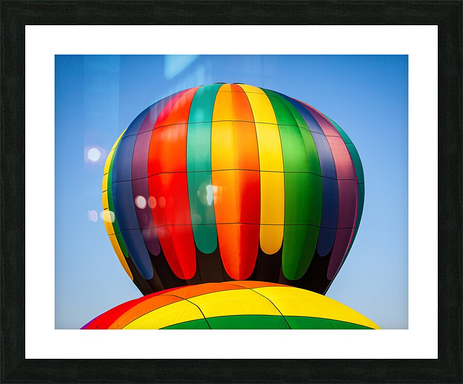 Colorful hot air balloon rising above another with blue sky Impression et Cadre photo