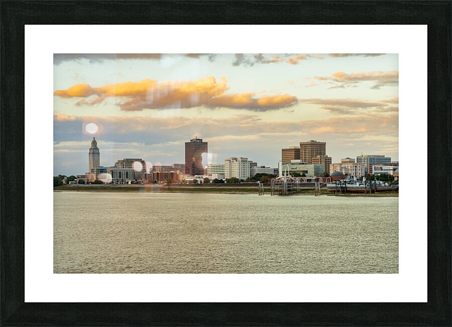 Skyline of Baton Rouge at sunset over river barges Picture Frame print