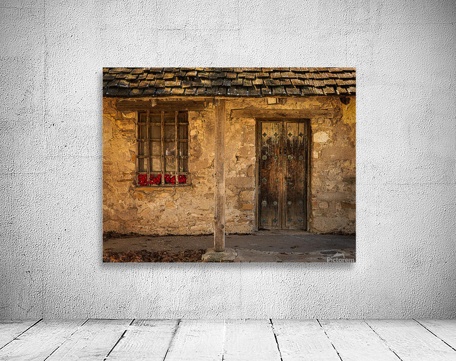 Rustic San Juan building with a barred window red flowers and a Wall Preview