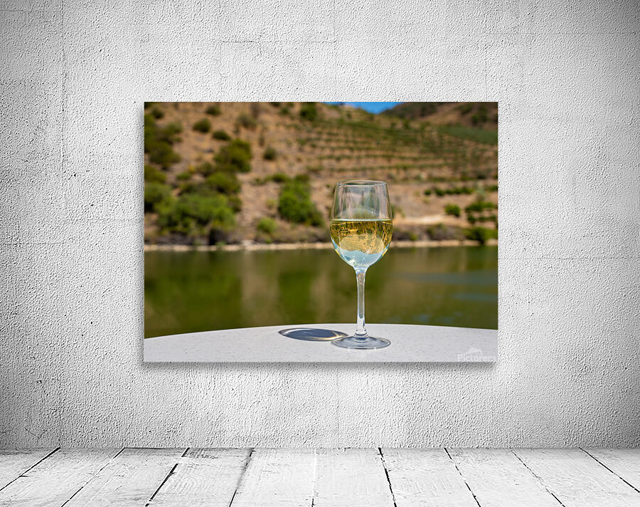 Glass of white wine by Douro river in Portugal Wall Preview
