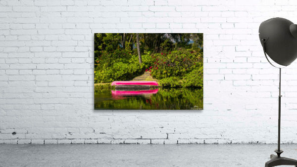 Red canoe on dock reflecting into calm lake or pond in garden Wall Preview