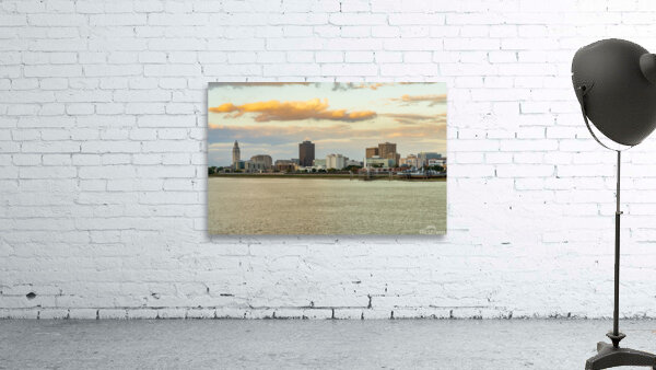 Skyline of Baton Rouge at sunset over river barges Wall Preview