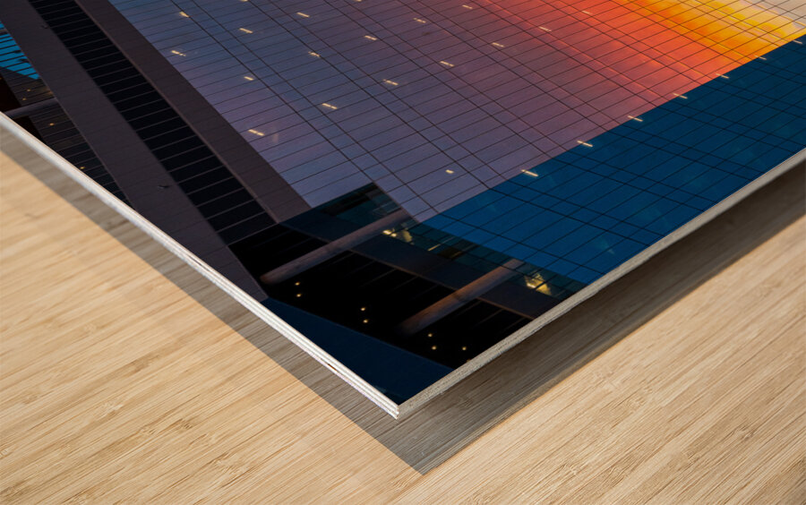 Brilliant sunset reflected in the glass of new office building Wood print