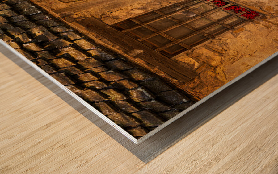 Rustic San Juan building with a barred window red flowers and a Wood print