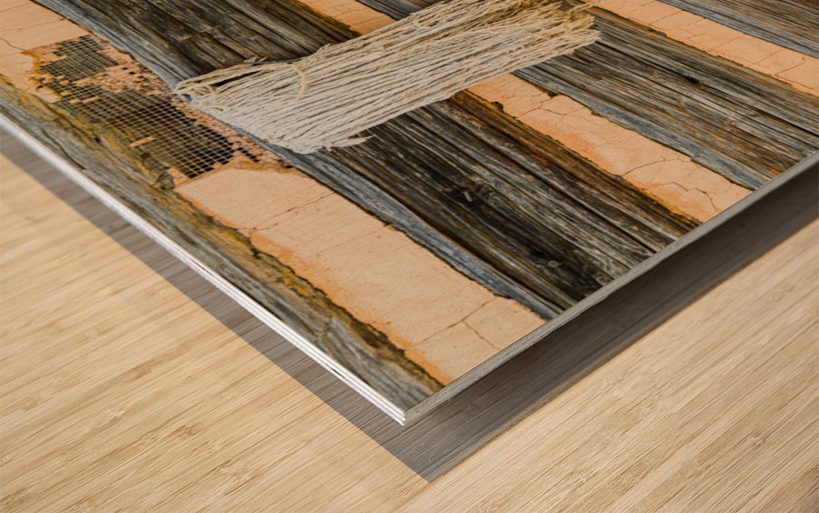 Old rake and mop against log cabin Wood print