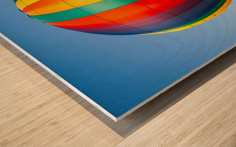 Colorful hot air balloon rising above another with blue sky Impression sur bois