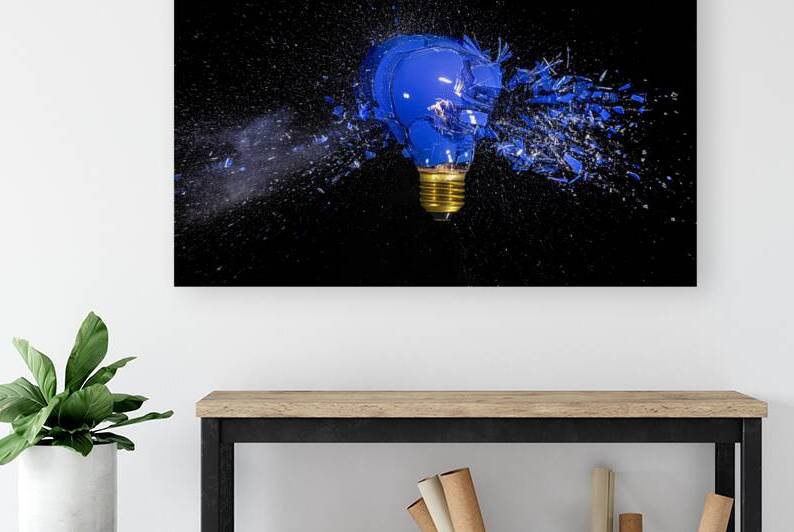 traditional blue bulb breaks and explodes on a black background. by Gualtiero Boffi