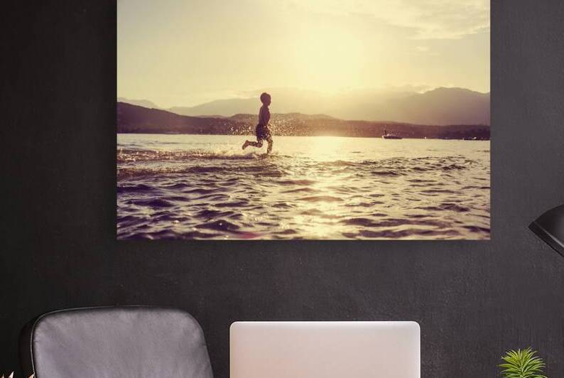 little boy runs happily into the sea  by Gualtiero Boffi