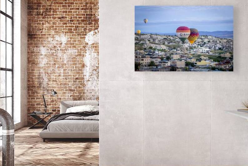 hot air balloons fly low over the city of goreme at sunrise by Gualtiero Boffi