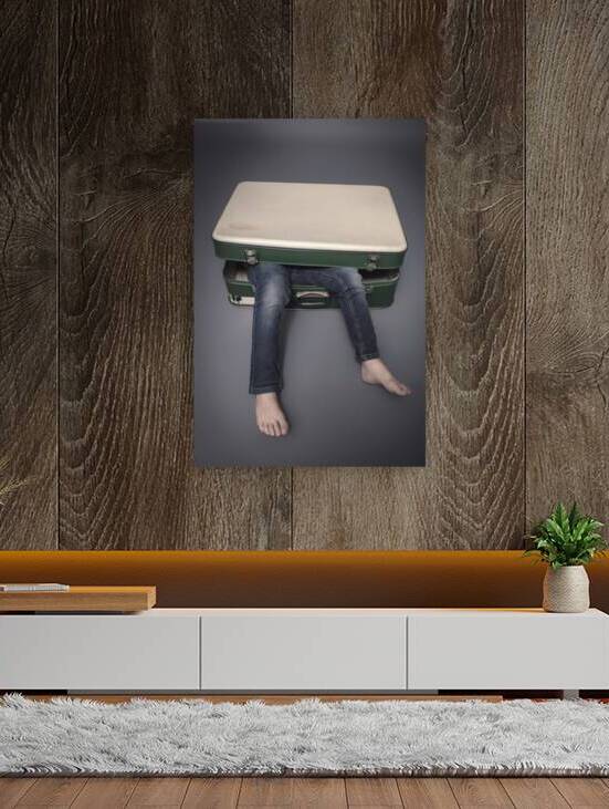 legs protruding from an old suitcase  by Gualtiero Boffi