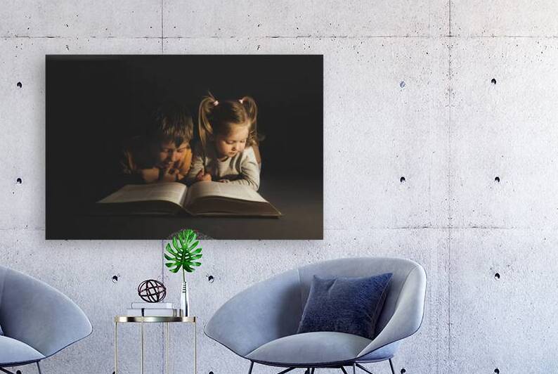 children lying reading a book by Gualtiero Boffi