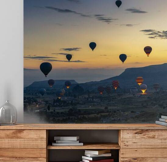 hot air balloons fly over the city of goreme at sunrise.  by Gualtiero Boffi