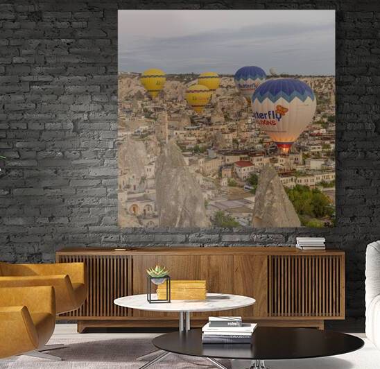 hot air balloons fly low over the city of goreme at sunrise by Gualtiero Boffi