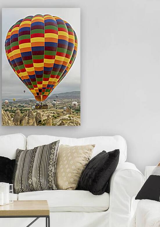 hot air balloons fly over the city of goreme. by Gualtiero Boffi