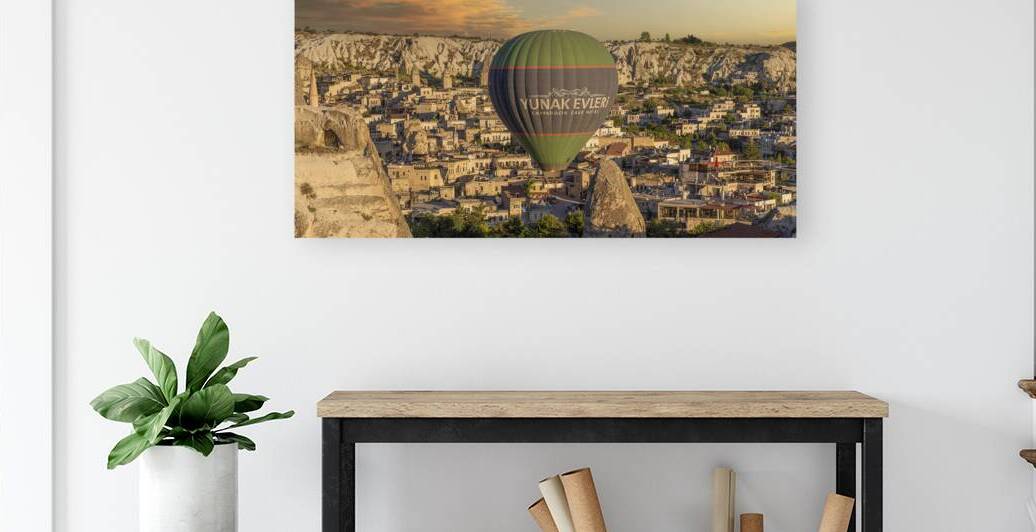 hot air balloon flies low over the city of goreme by Gualtiero Boffi